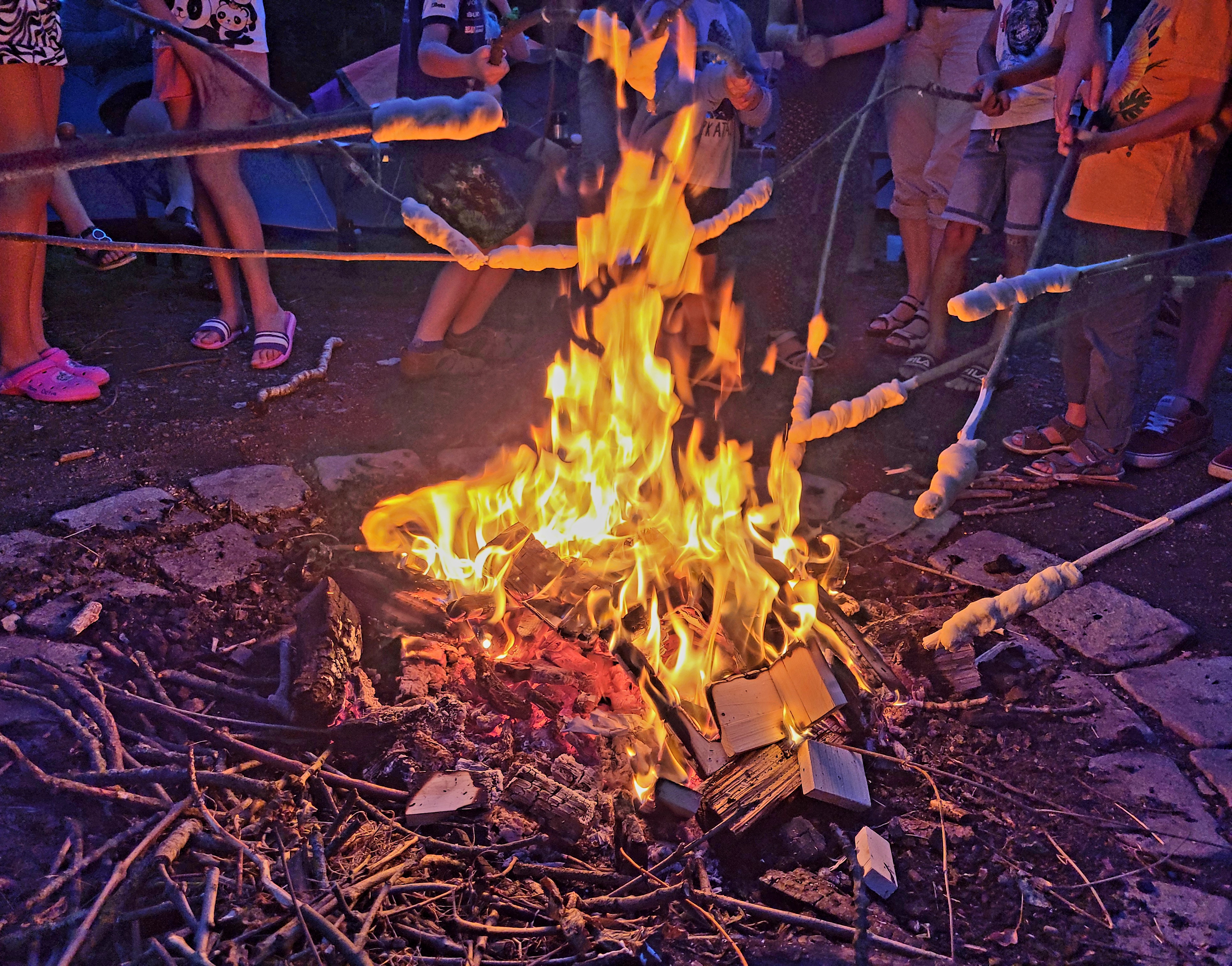 Adventure camp at a lake, here bread on a stick.