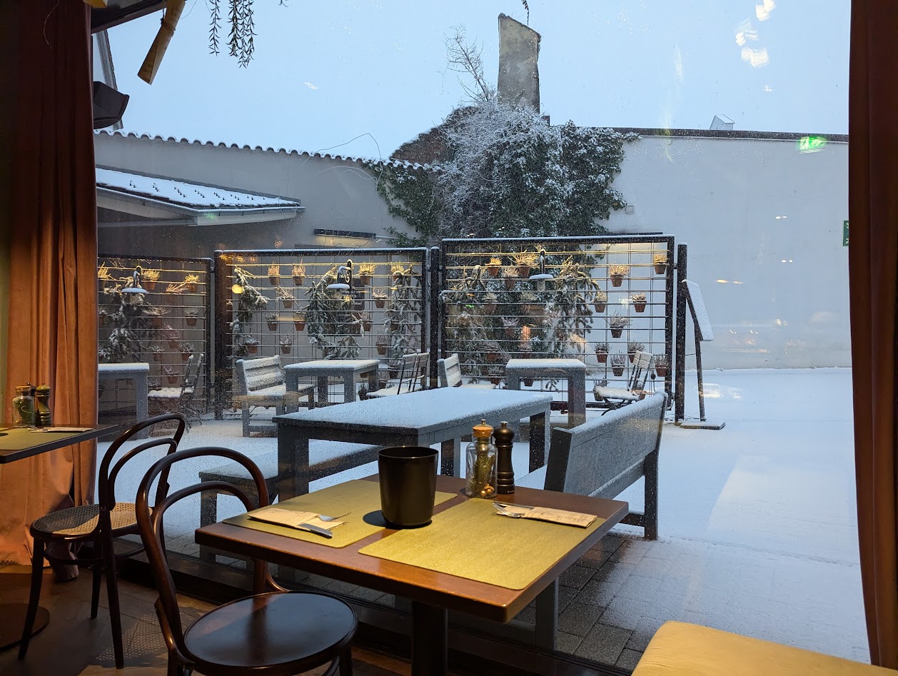 Outside of the breakfast room in a hotel the snow starts falling.